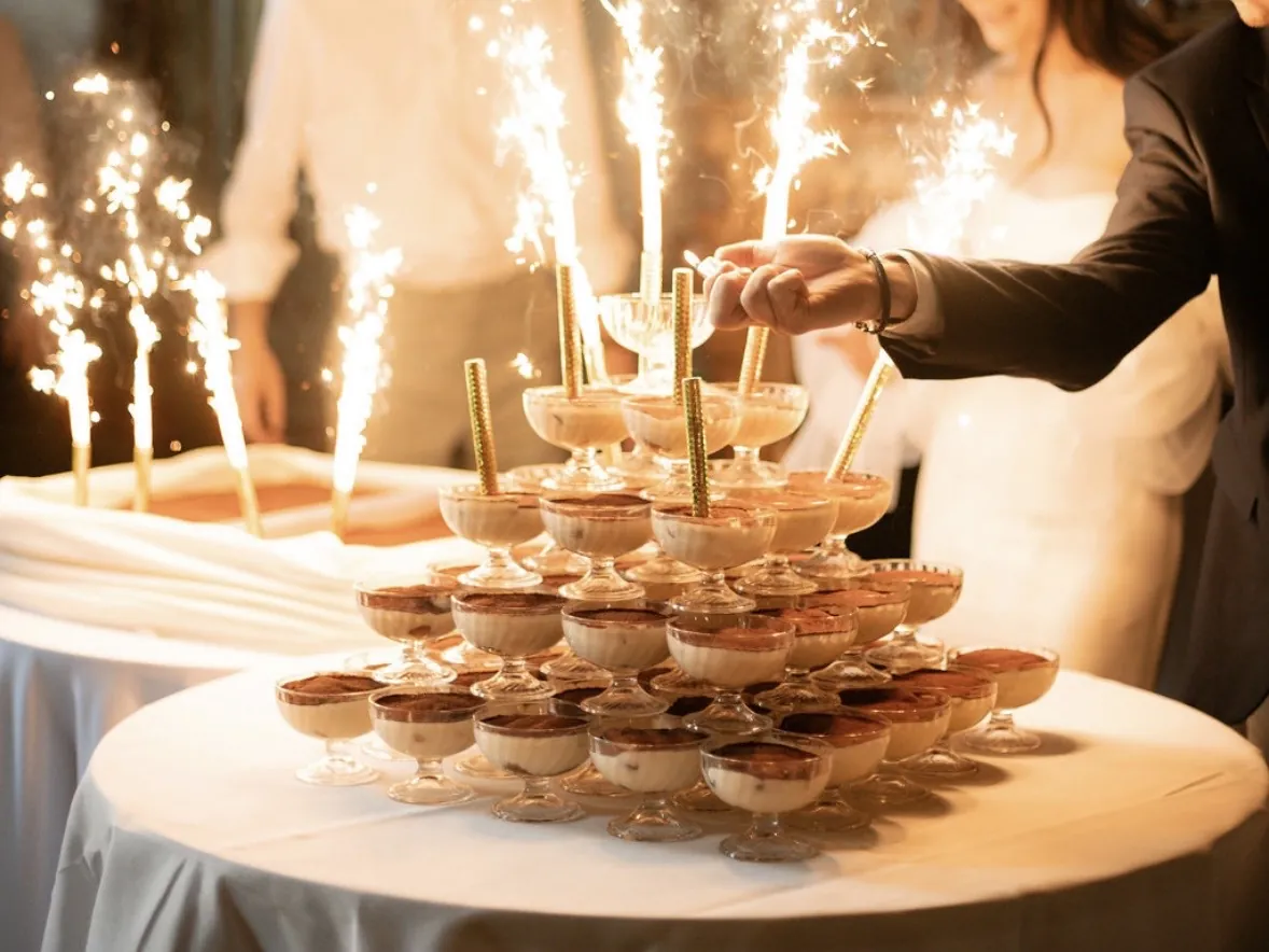Une pyramide de desserts en coupes, illuminée par des fontaines d’étincelles, lors d’une célébration