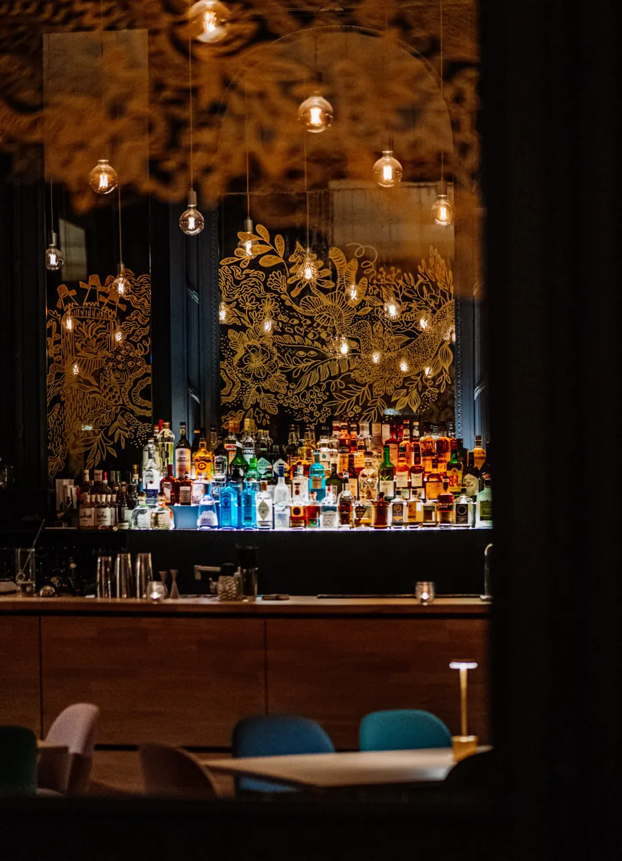 Le Salon Bleu : le bar illuminé et les tables dressées